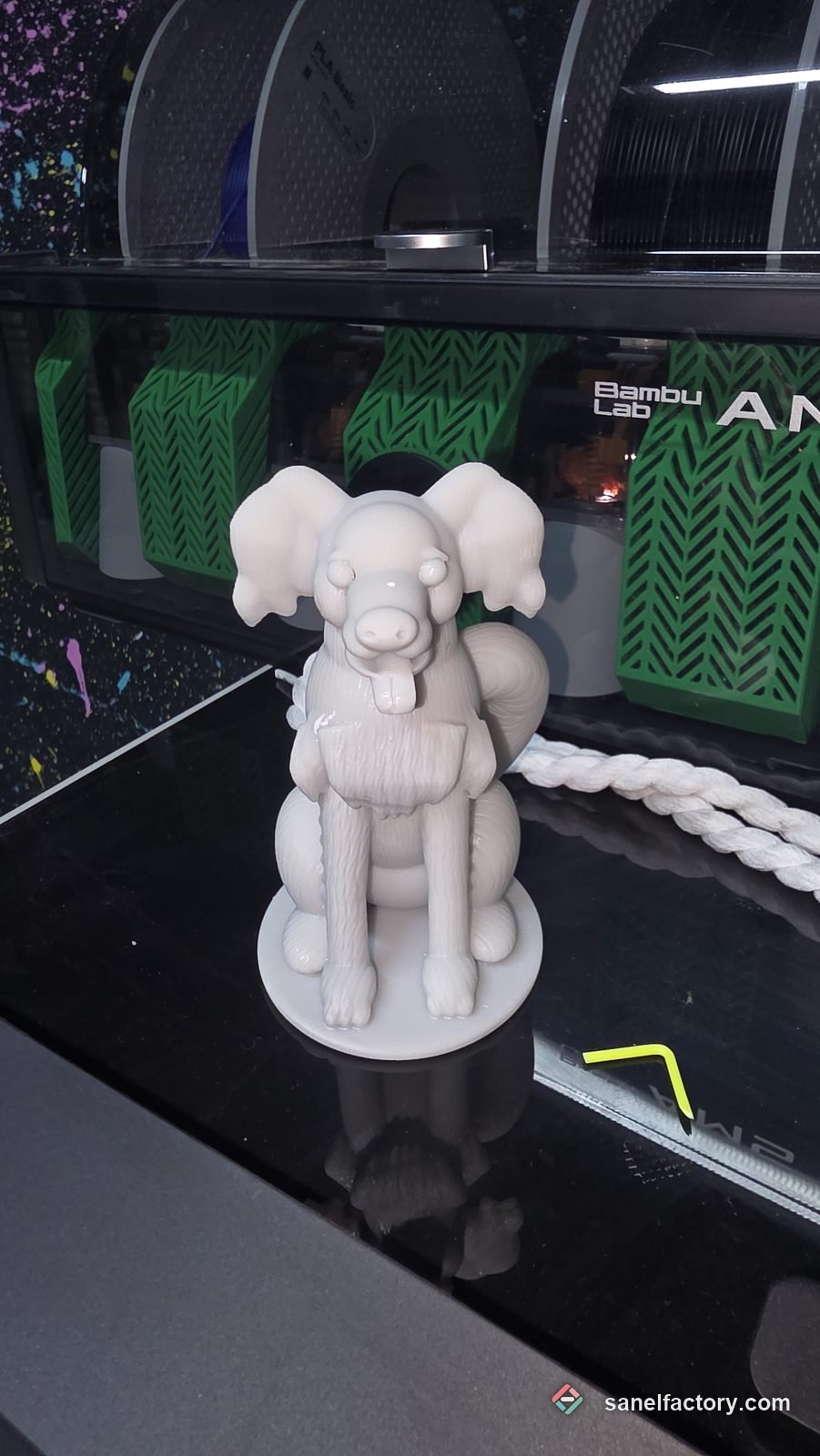 Figurină cu un câine din rășină gri, pe o bază rotundă