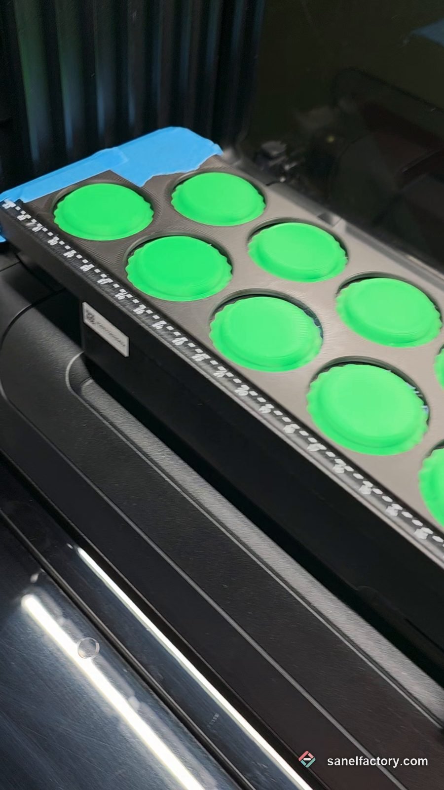 Jetoane verzi printate 3D, puse în suportul imprimantei UV EufyMake E1 înainte de imprimarea logo-ului